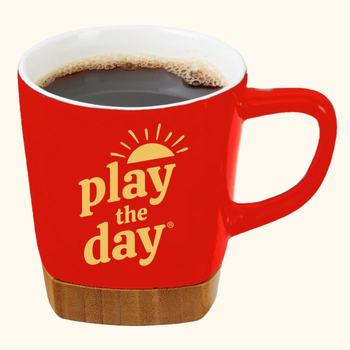 11 oz red ceramic mug with yellow Play the Day® logo and removable bamboo coaster