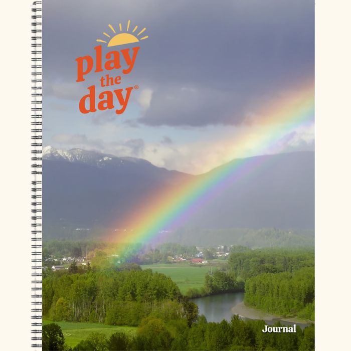 8.5 x 11 Play the Day® recycled paper journal cover with a rainbow arching over the Skykomish River valley