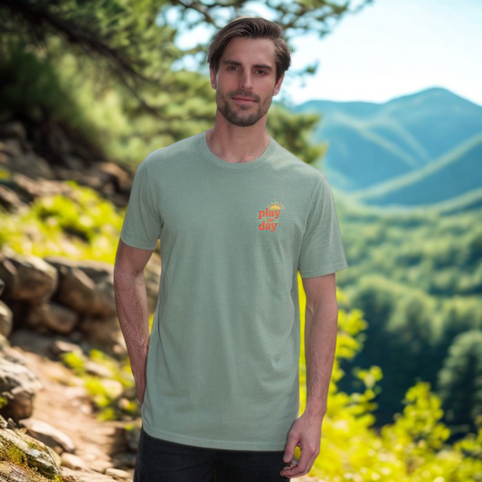 Man wearing a green t-shirt with a logo in a mountainous landscape