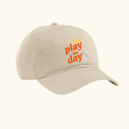 Beige unconstructed organic cotton twill cap with orange Play the Day® logo