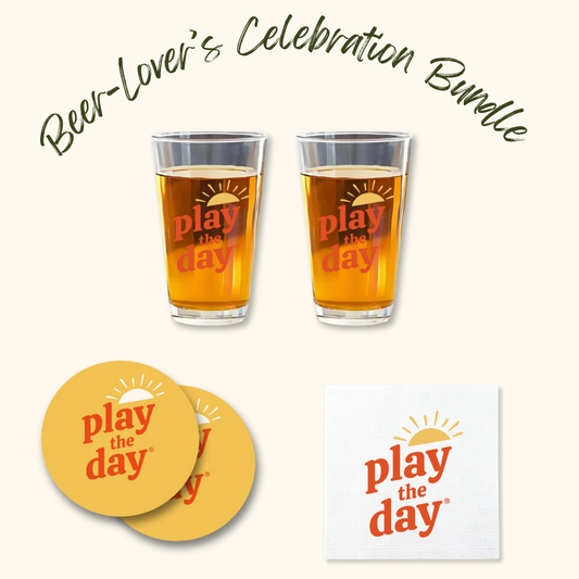 Play the Day® Beer-Lover’s Celebration Bundle with two pint glasses, two recycled-paper coasters, and napkins featuring the Play the Day® logo.