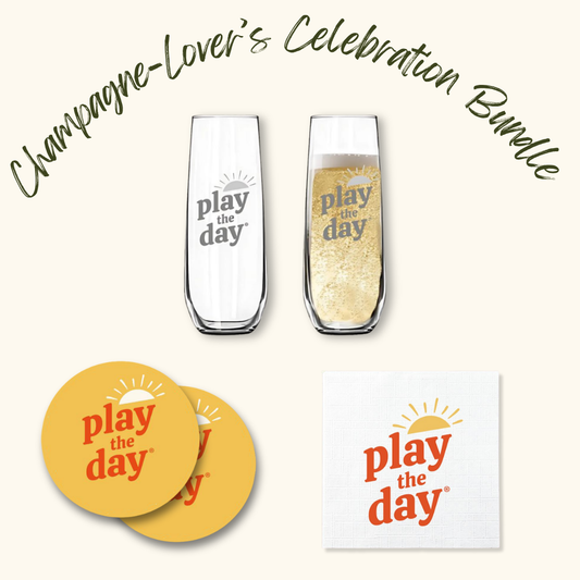 Play the Day® Champagne-Lover’s Celebration Bundle with two champagne flutes, two recycled-paper coasters, and napkins featuring the Play the Day® logo.