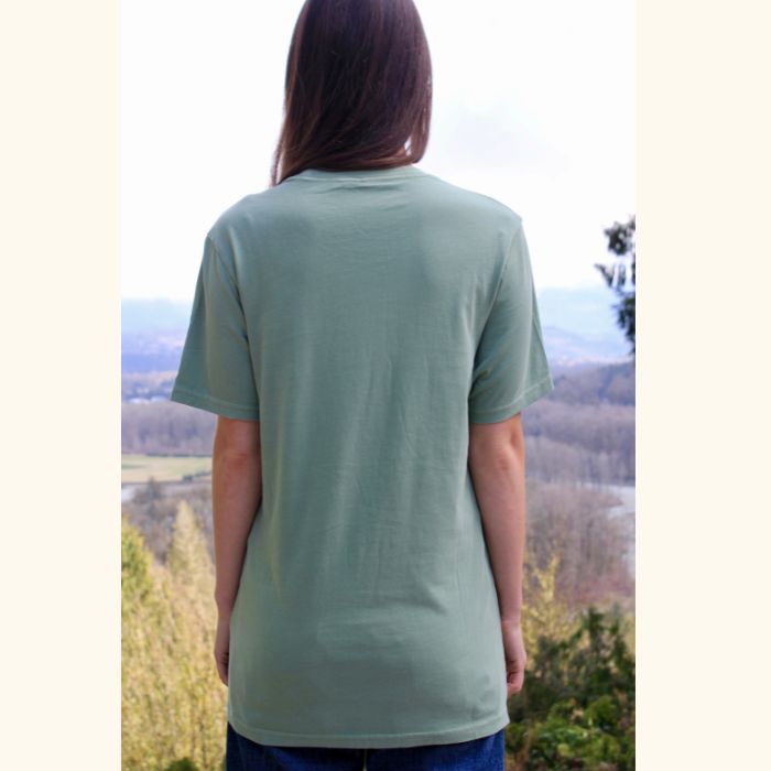 Back view of green Play the Day® unisex t-shirt worn by woman outdoors