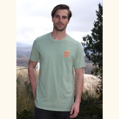Man wearing green Play the Day® unisex t-shirt, front view with scenic backdrop
