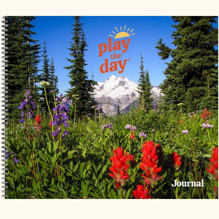 Play the Day® journal cover with alpine wildflowers and pine trees beneath a mountain peak