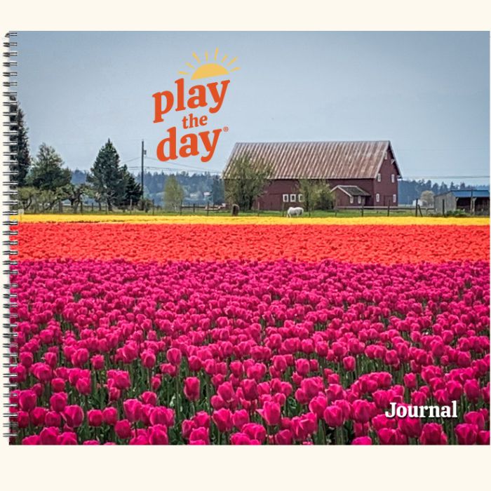 Play the Day® journal cover with vibrant tulip fields and a red barn in the background