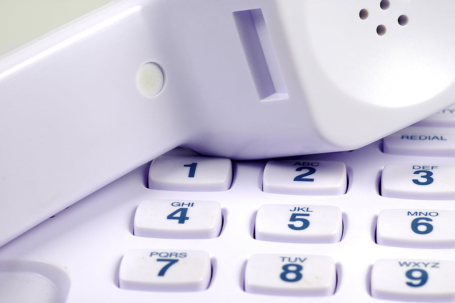Close-up of a vintage touch-tone phone, symbolizing contact with Play the Day®